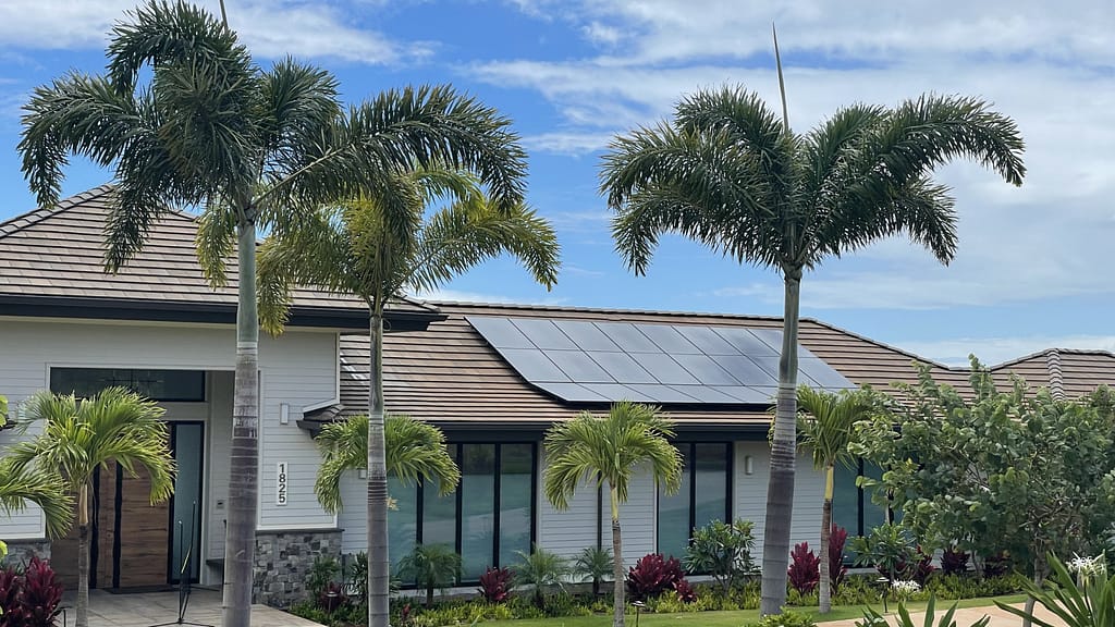 tress and house with solar panel over blue sky