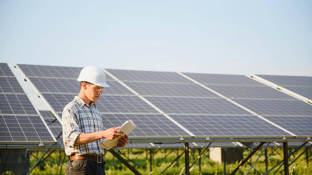 person inspecting solar panels