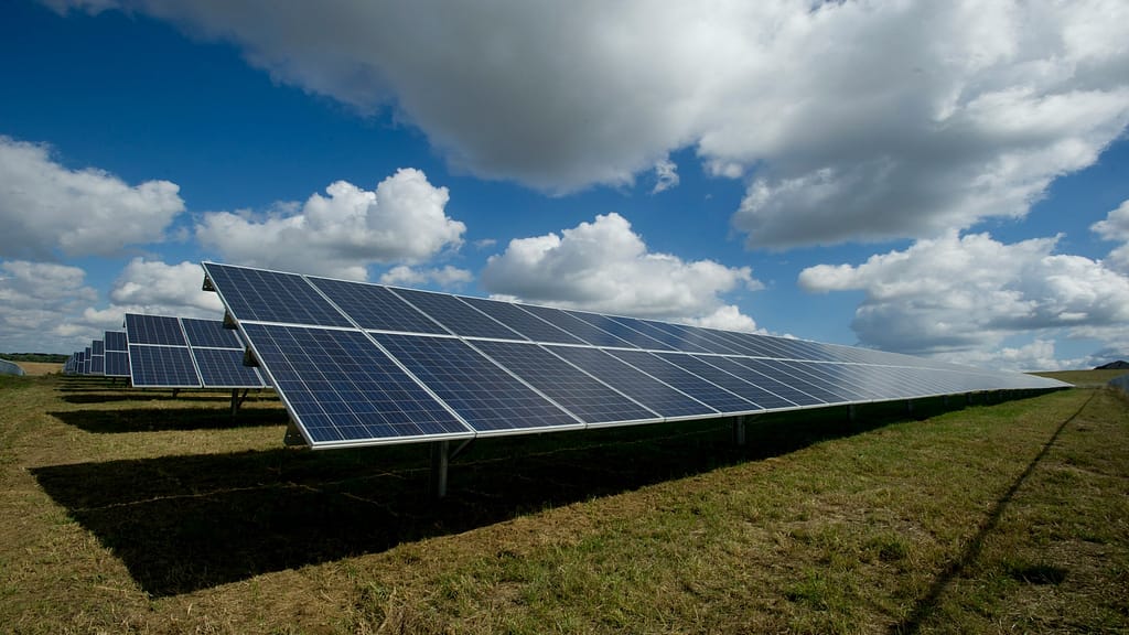 ground mounted solar panels over blue and cloudy sky