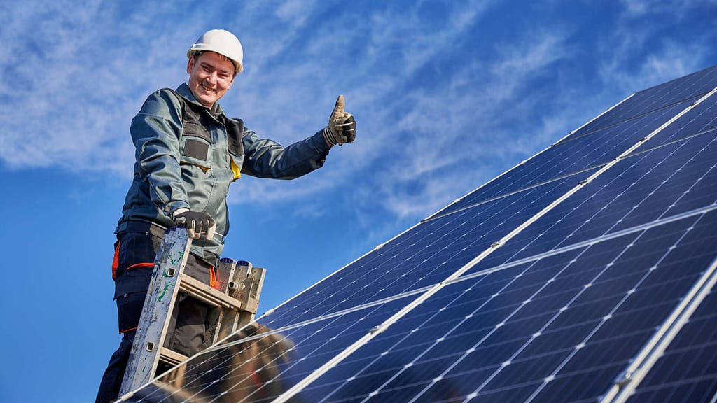 technician smiling while working on solar panels