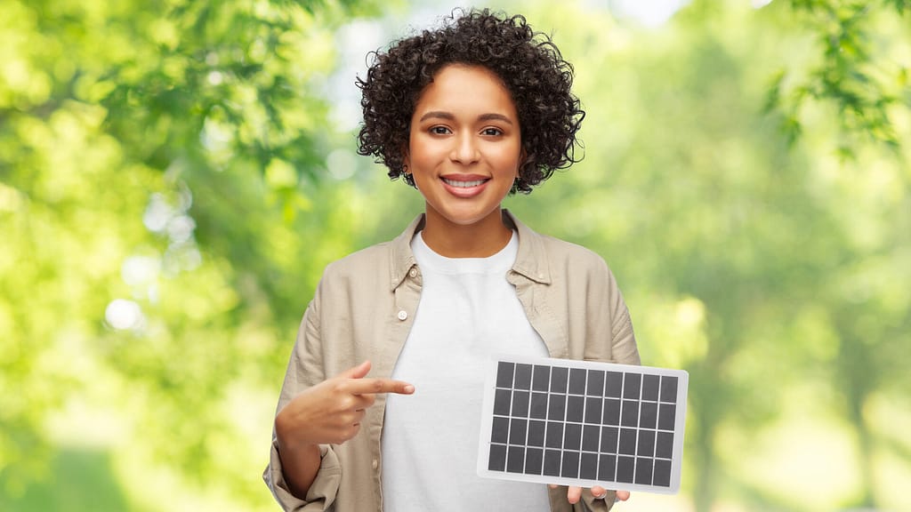 woman smiling while holding a solar battery model