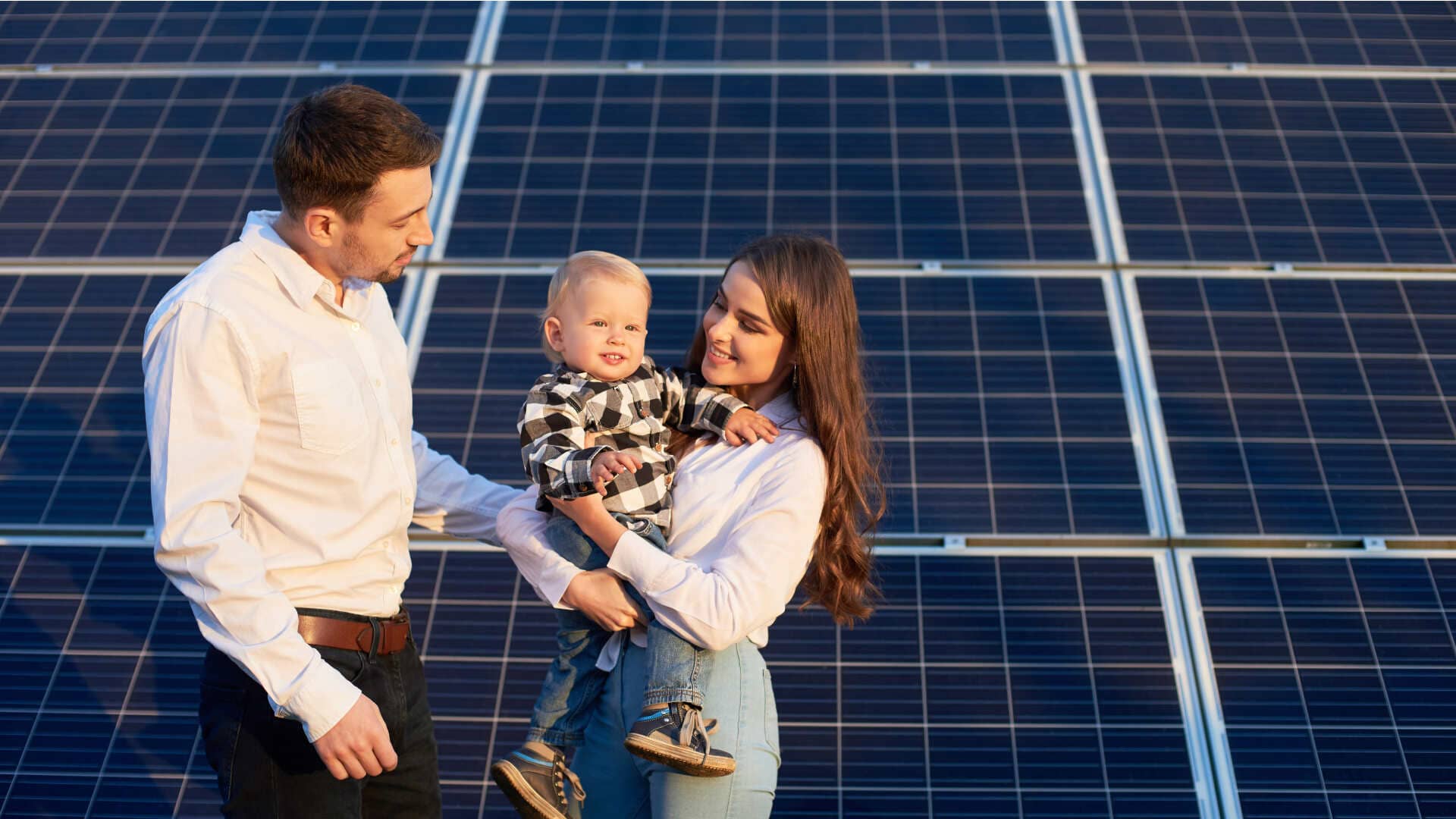 Family standing in front of solar panels
